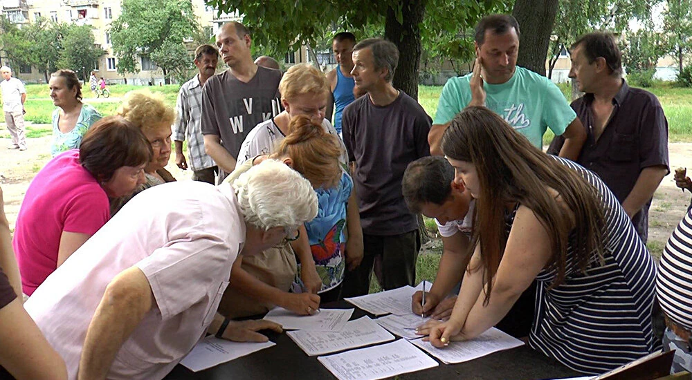 люди на собрании жильцов обсуждают вопросы